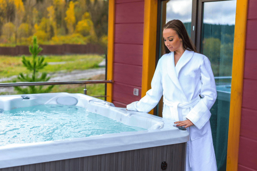 GFD Homes square hot tub: Lady wearing gown =, leaning over bubbling hot tub. 