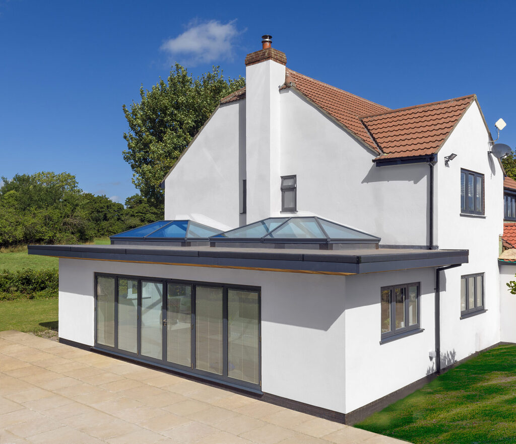 A wraparound extension with roof lanterns bathed in sunlight
