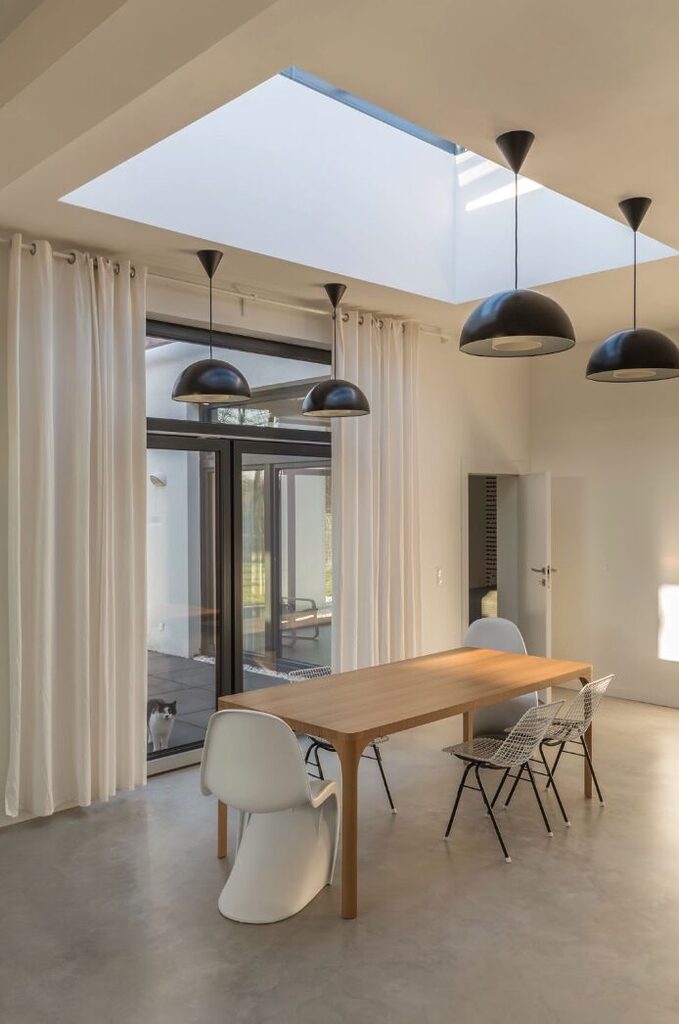 GFD Homes Roof lantern installed above dining table with black oval lights hanging from ceiling.