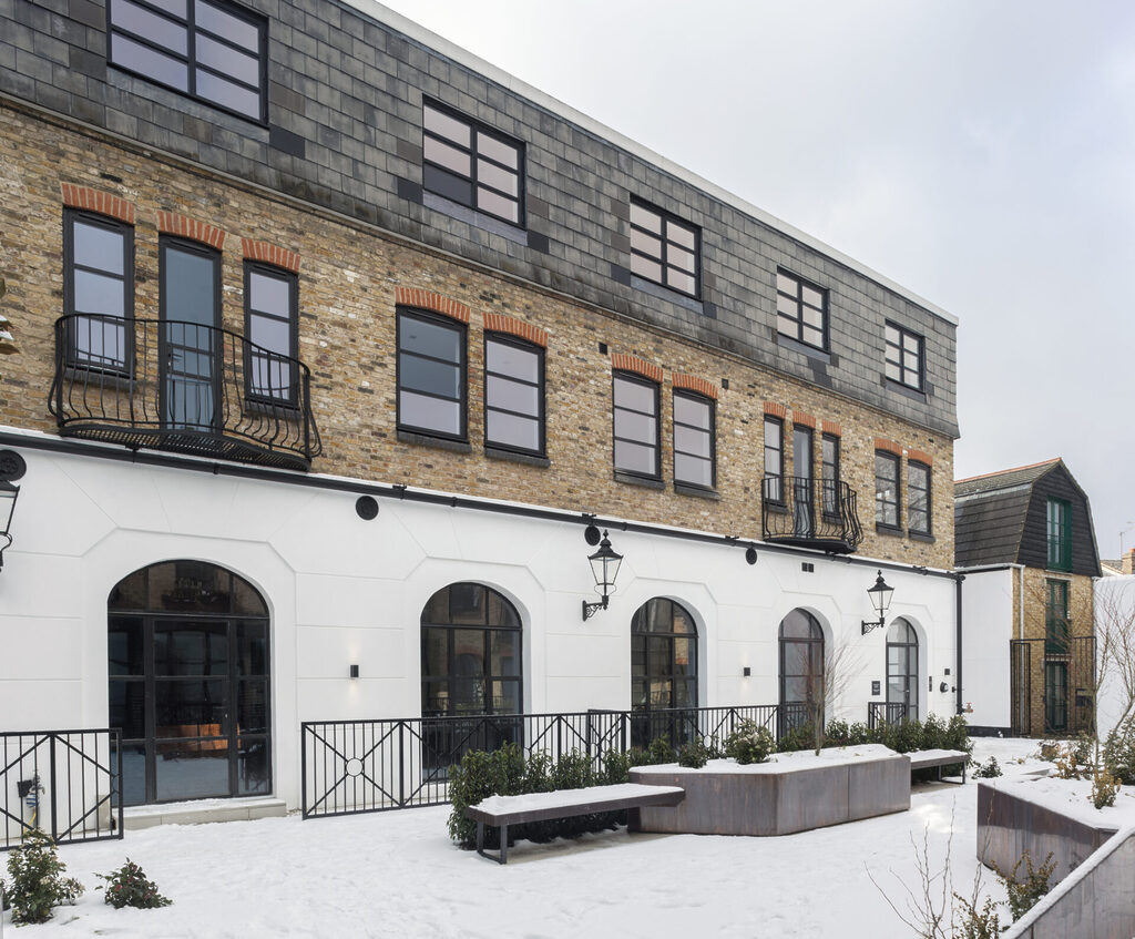 GFD Homes aluminium framed windows: Side view of a large commercial property with large, black aluminium windows. 