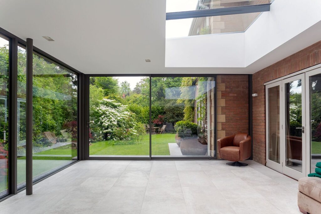 GFD Homes aluminium sliding patio doors closed and from the interior of an orangery looking out into the garden and patio 