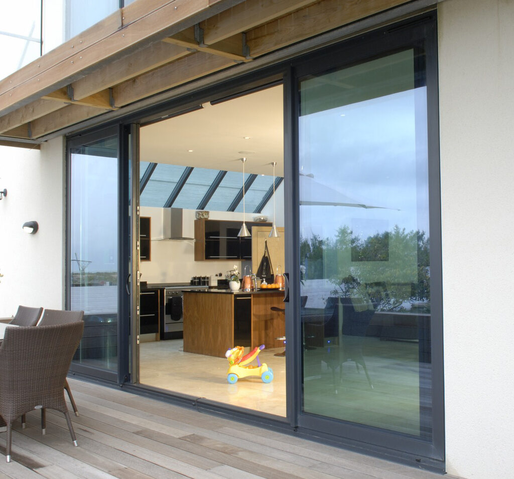 GFD Homes sliding aluminium patio doors : Exterior shot of a house looking into the kithcen through open sliding aluminium patio doors 