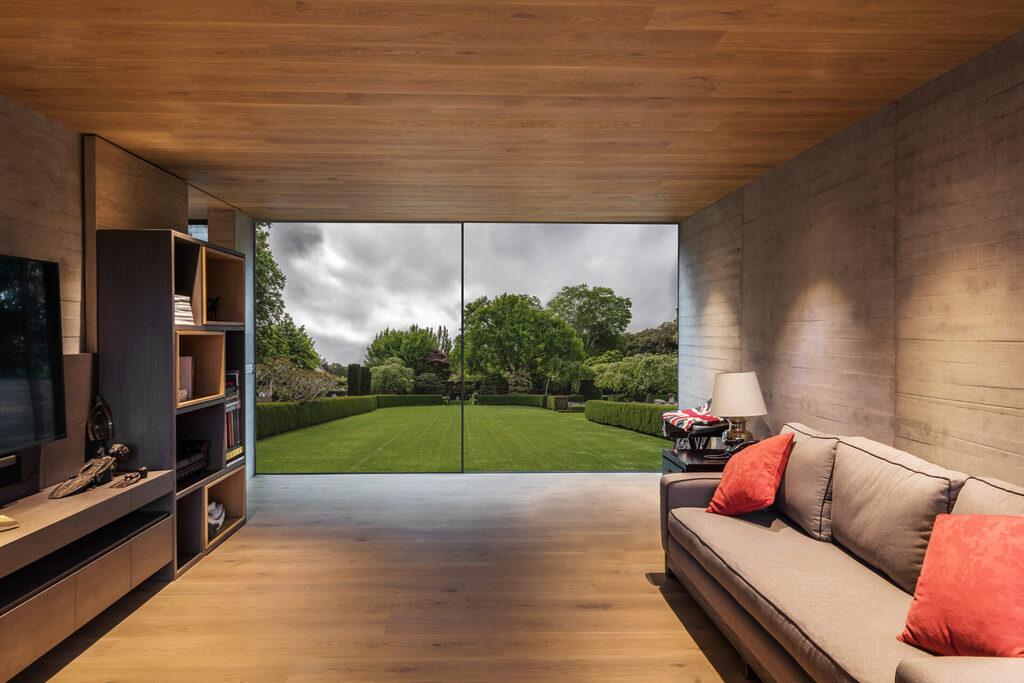 GFD Homes aluminium sliding doors near me : looking out onto a overcast garden from the comfort of a wooden tilled room