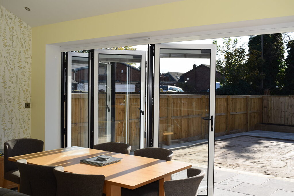 GFD Homes benefits of bifold doors : looking out into a patio area from inside an extension through bifold doors 