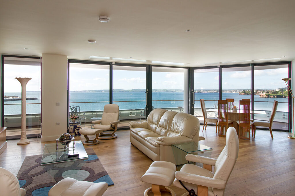 GFD Homes sliding aluminium doors : Interior hot of an ocean front house looking out at the sea thank to the sliding aluminium doors