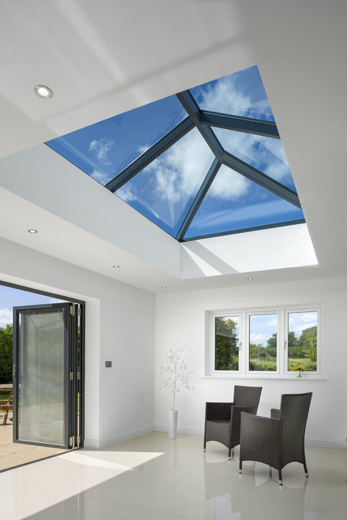 GFD Homes how to fit a korniche roof lantern: Looking up at roof lantern installed above living room with bifold doors opened wide.