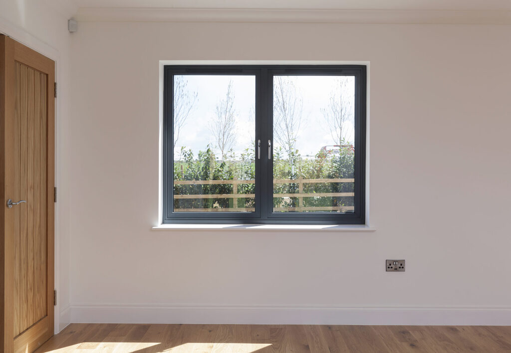 GFD Homes how to fix condensation in double glazing: Bedroom interior shot looking at a closed double glazed aluminium window. 