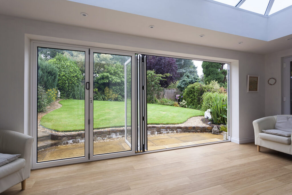 GFD Homes aluminium bifold doors vs upvc : Looking outside into a pattio through a semi open aluminium bifold doors 