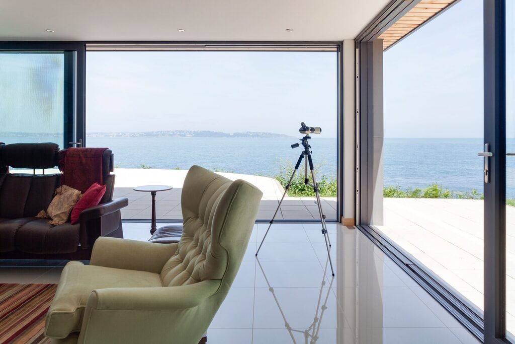 GFD Homes How to secure Patio Doors : Sliding doors positioned together to create a glass corner. Sea view in background. 