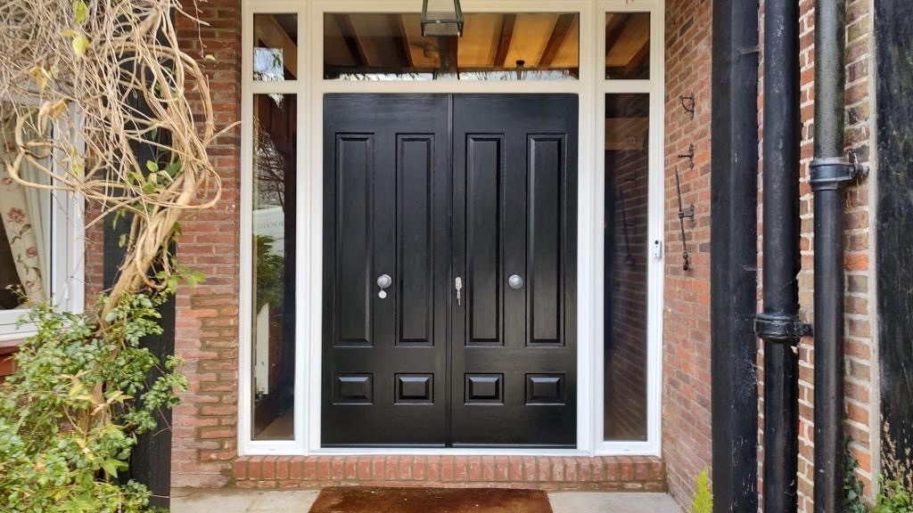 GFD Homes black door: French black doors with glass side panels and a white frame. 