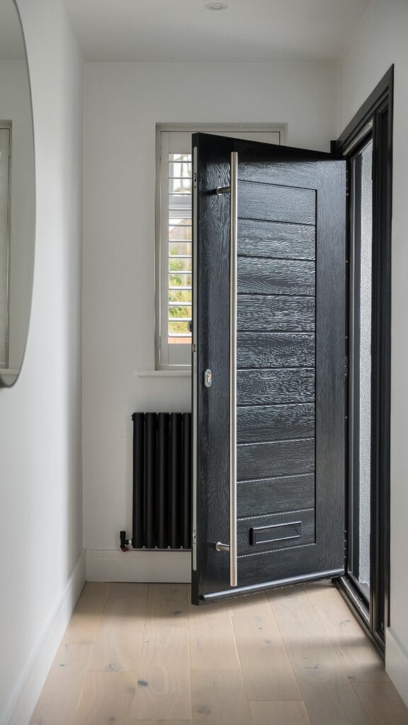 GFD Homes black door: black modern style composite door with long bar handle. 