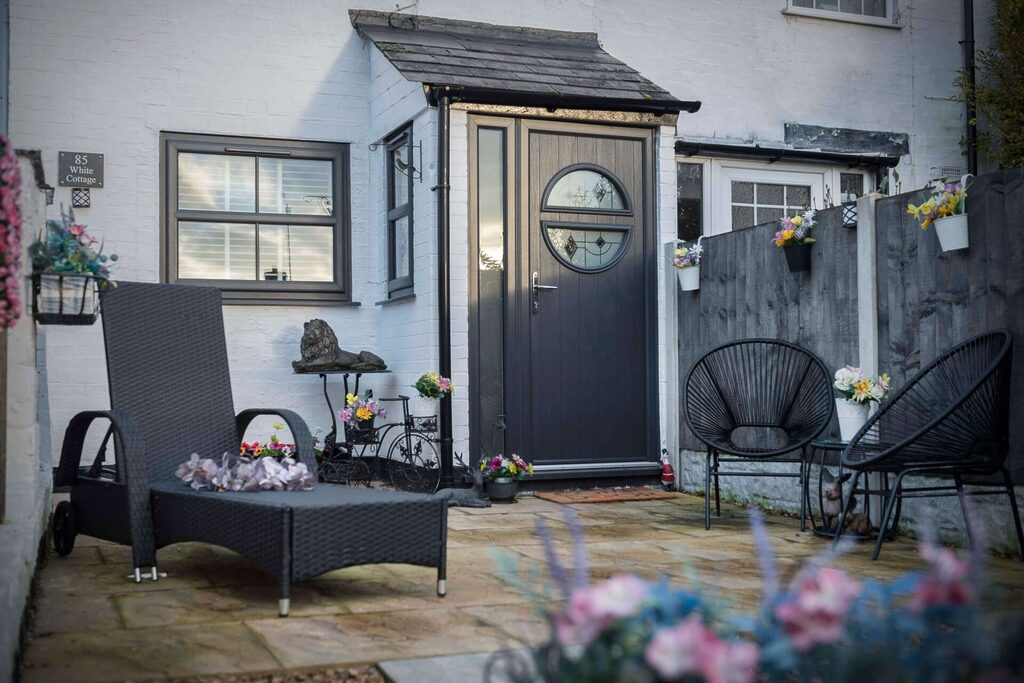 Red Doors: Grey comp door with front entrance in view with seating. 