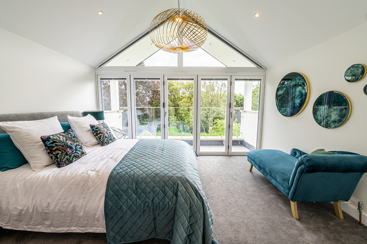 concertina doors: bedroom with 5 pane bifold door and view in background.