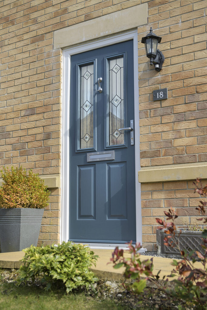 external doors: side view of composite door with plants surrounding the door. 